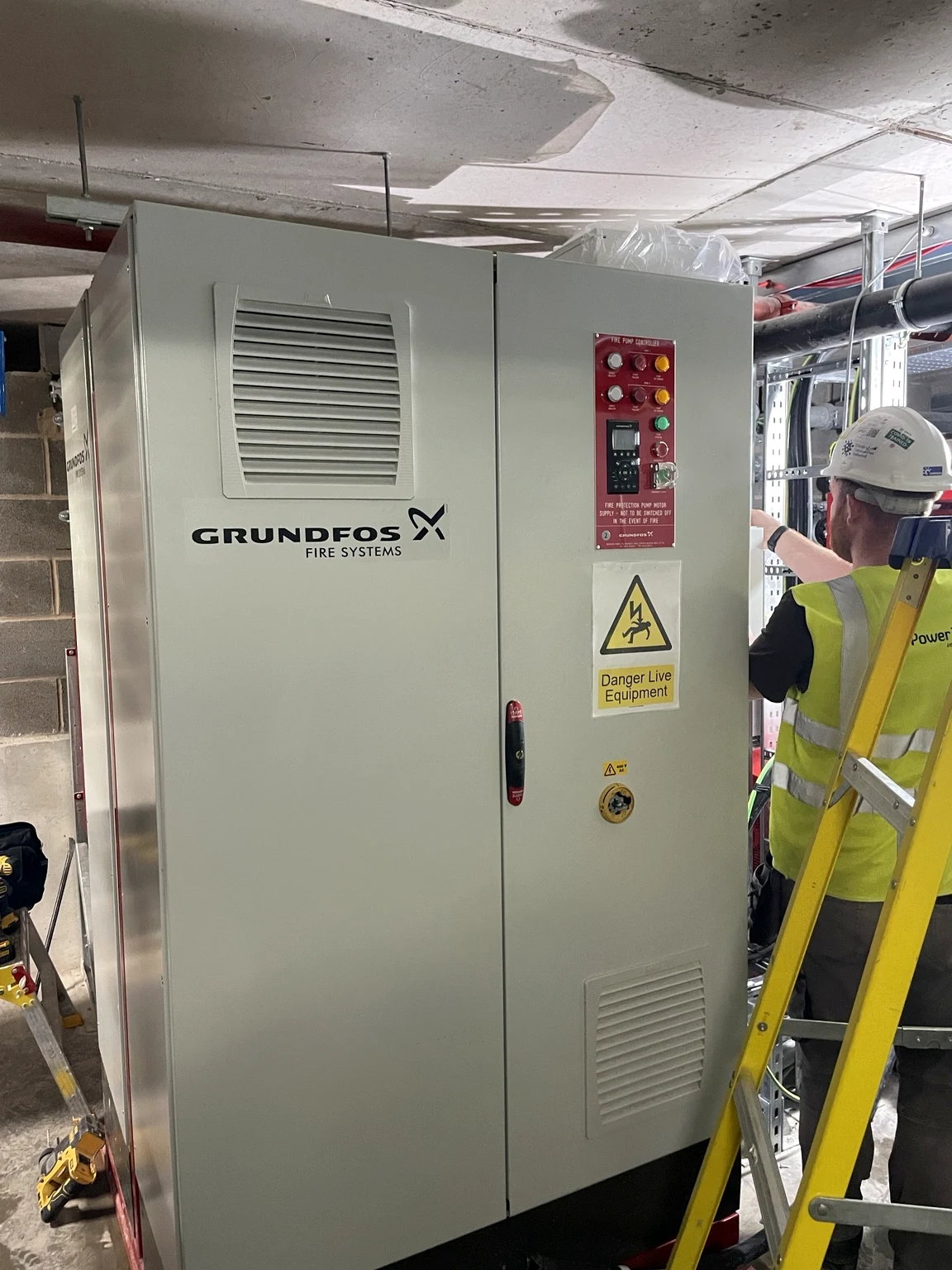 Power Tech engineer working beside a fire pump controller
