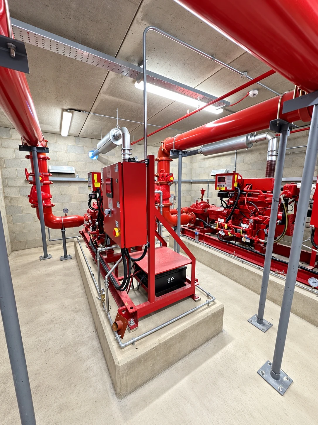 Fire sprinkler pump room with control equipment and red pipework